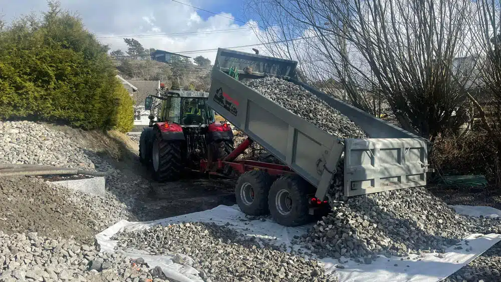 Traktor massetransporterer steinmasser